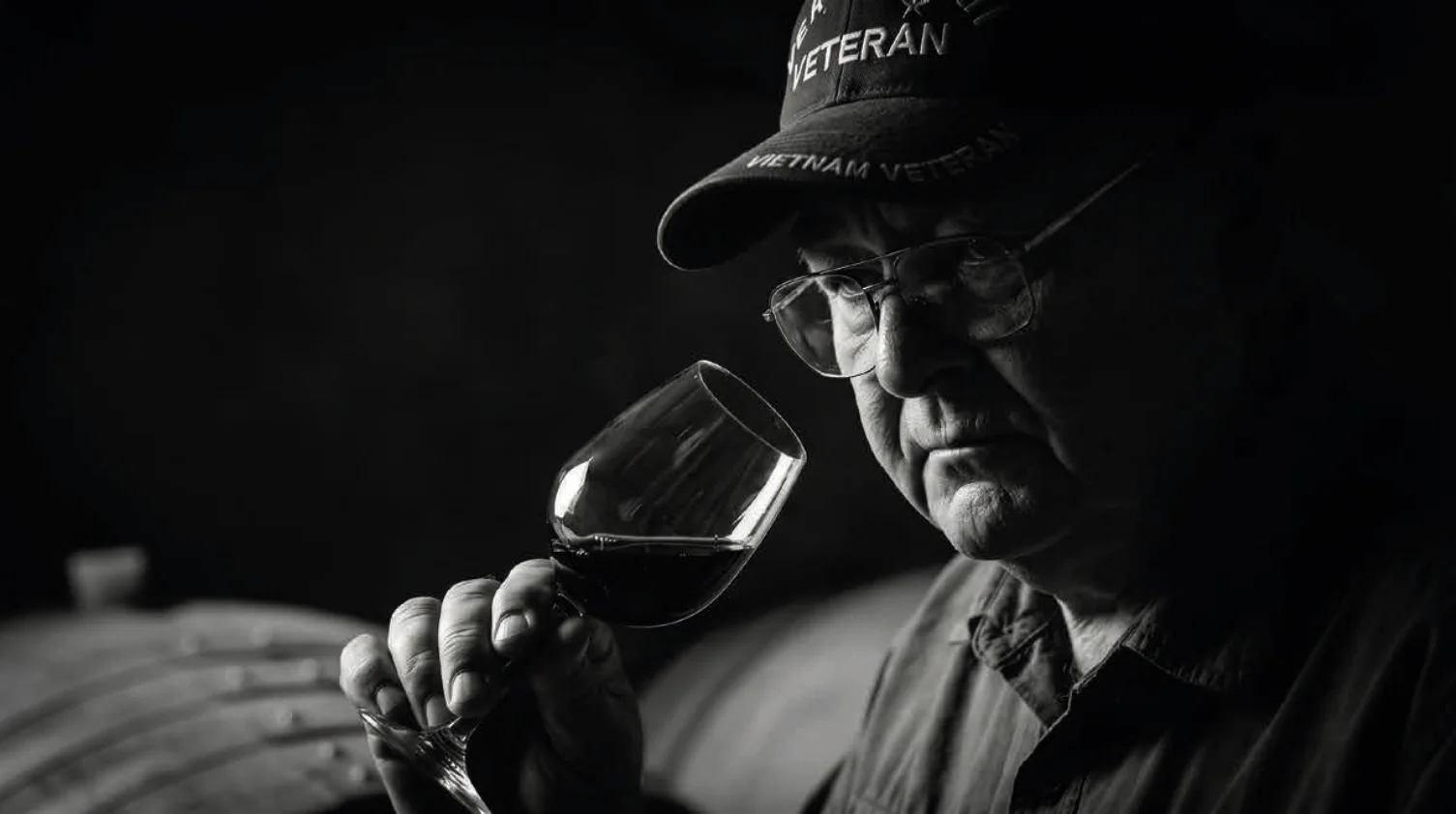 Jim Eddins catando un vino tinto en la bodega — retrato en blanco y negro